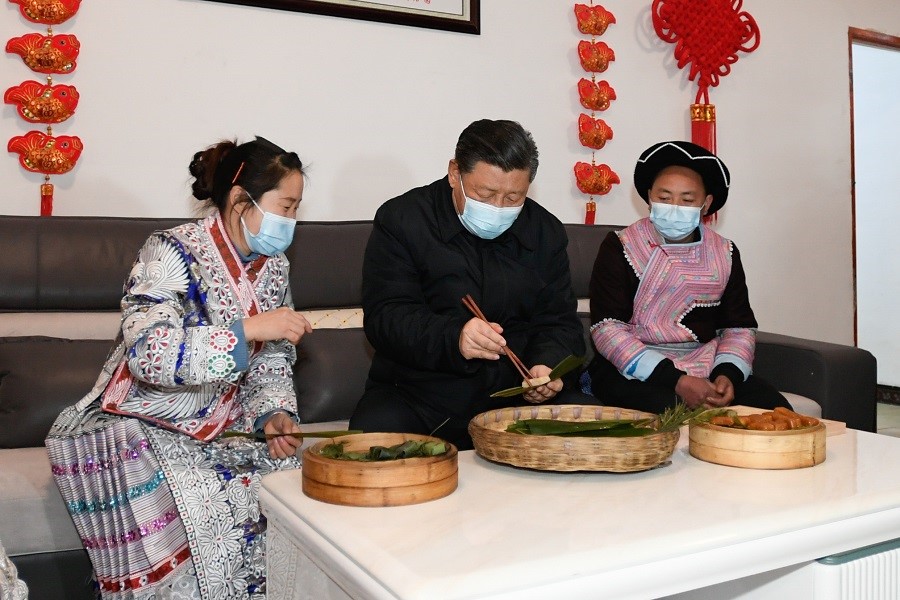 2021年2月3日下午，習(xí)近平在貴州畢節(jié)市黔西縣新仁苗族鄉(xiāng)化屋村苗族村民趙玉學(xué)家，同一家人邊聊家常邊制作當(dāng)?shù)貍鹘y(tǒng)節(jié)日食品黃粑。新華社記者 李學(xué)仁 攝